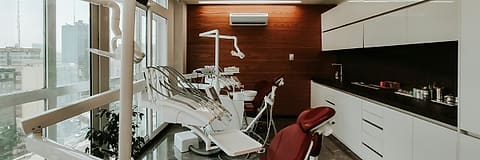 A dental treatment room with the chair and instrument arm ready for the next patient.